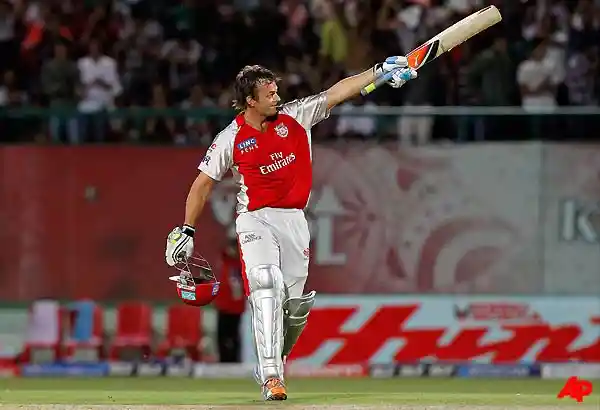 Gilchrist raising his bat after reaching his century; Image Source: indiatvnews.com 