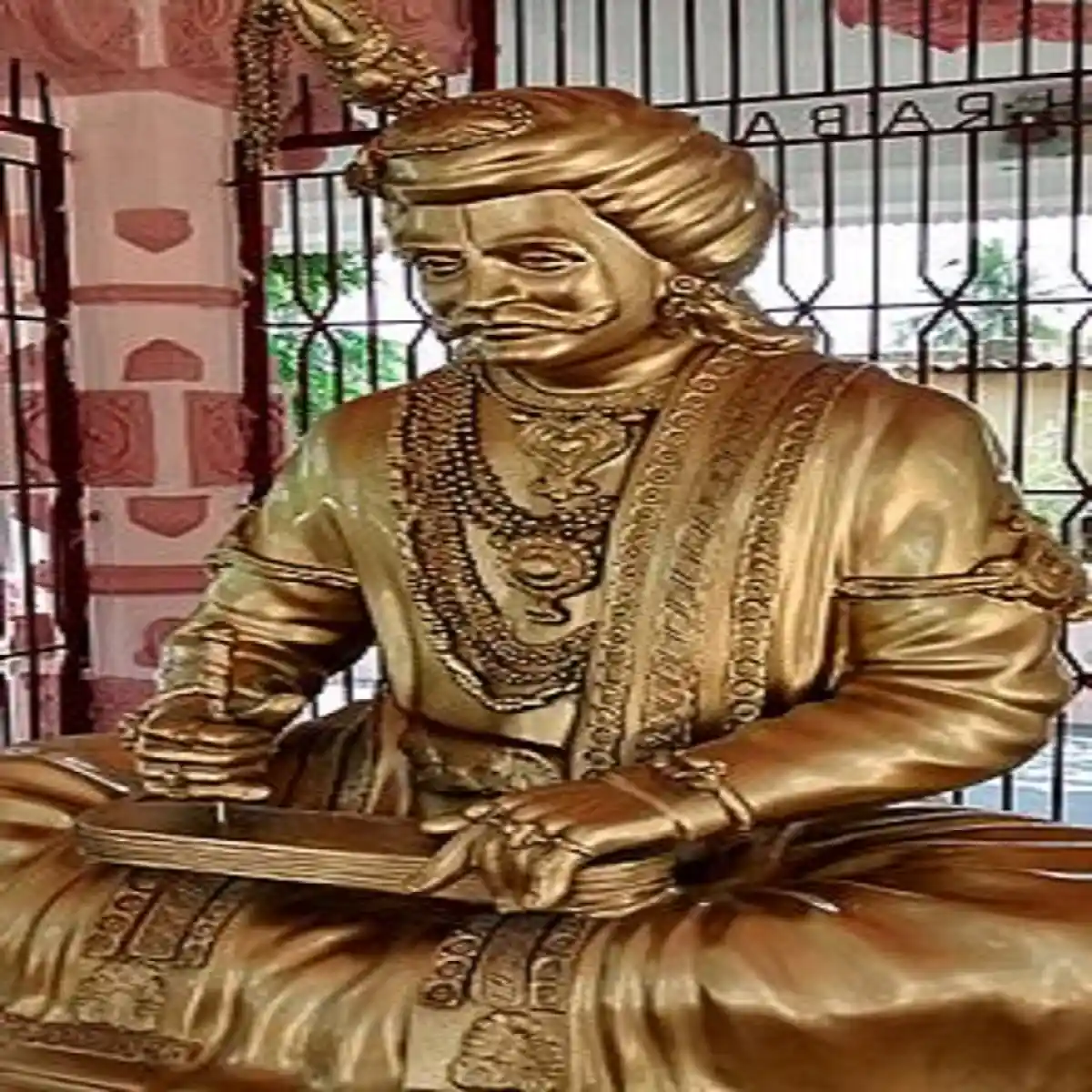 Krishnadeva Raya in a sitting position composing something; Image Source: Wikipedia