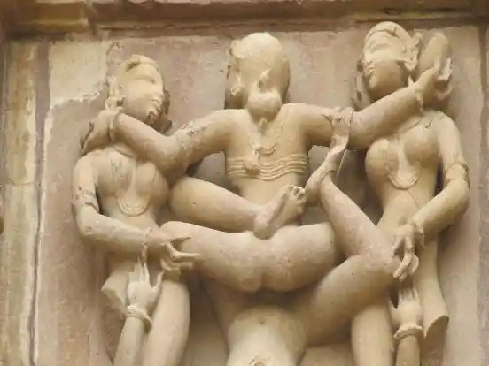 A sculpture at Khajuraho, portraying three women pleasuring a man and one another. Image Source: Daily O 